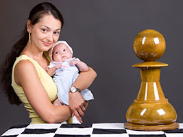Francesca, the daughter of Granmaster Alexandra Kosteniuk poses with chess pieces